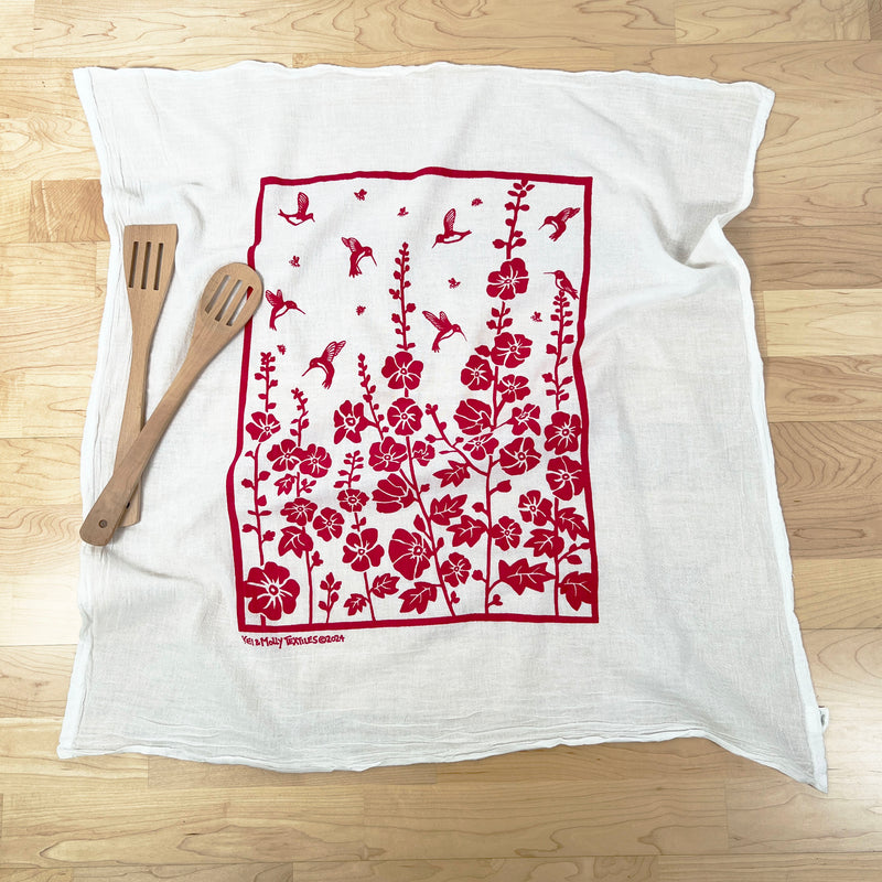 Kei & Molly Hummingbirds Flour Sack Dish Towel in printed in Raspberry color, Front view with  wooden props