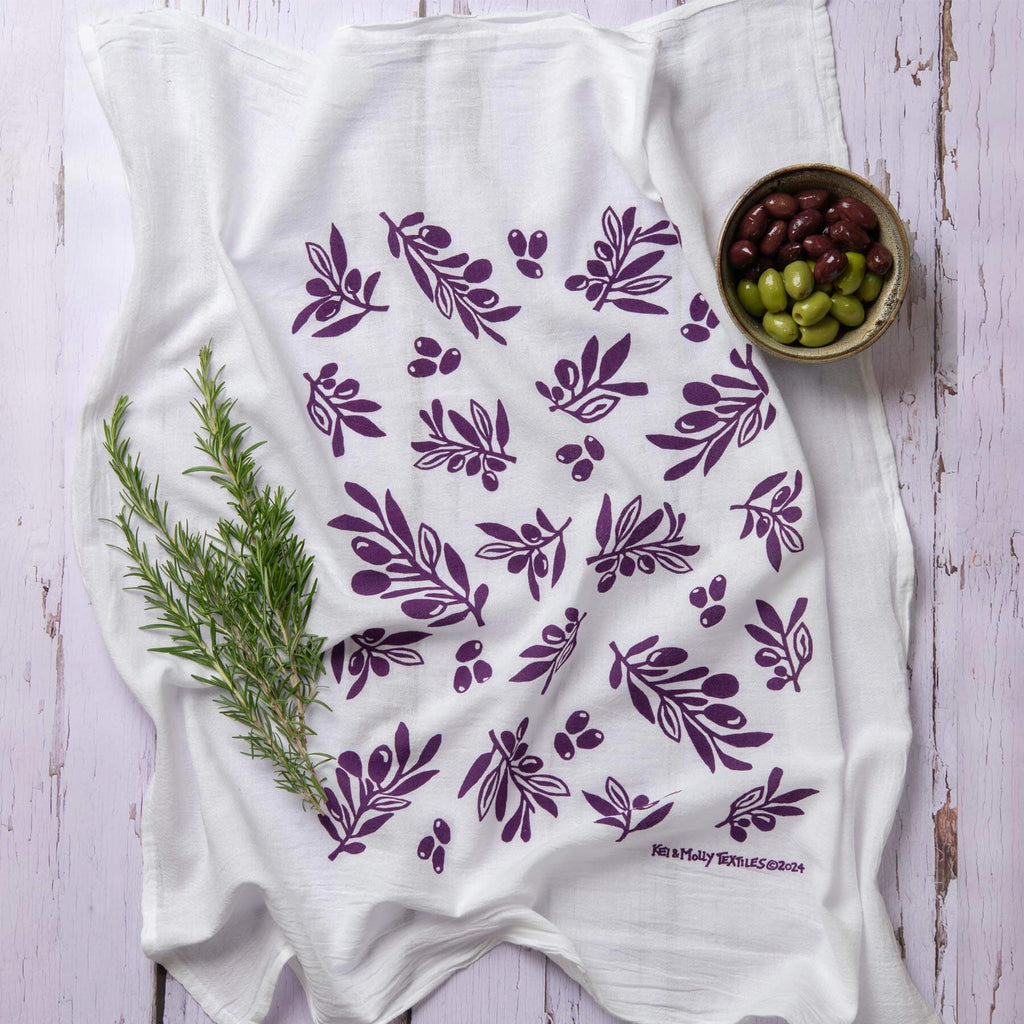 Kei & Molly Olive flour sack dish towel printed in Grape color, front view with props